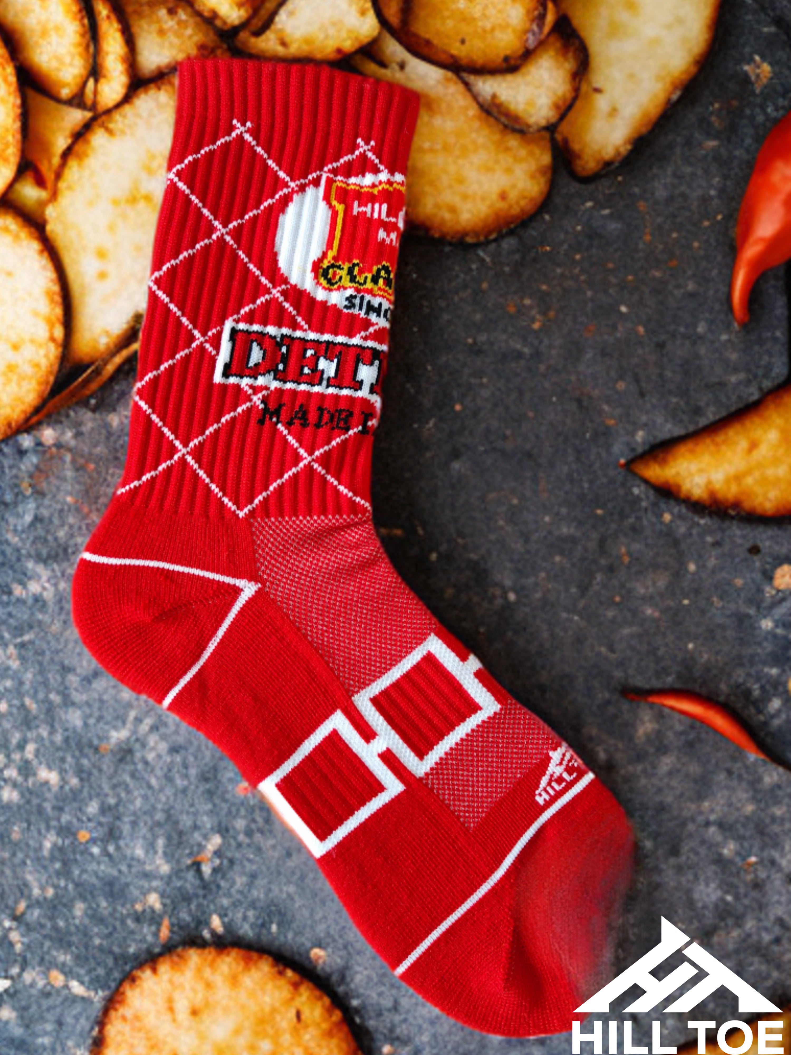 Hill Toe Chip Off the Sole sock in bold red, designed with breathable mesh and arch support — a fiery nod to Detroit’s favorite spicy chip flavor.
